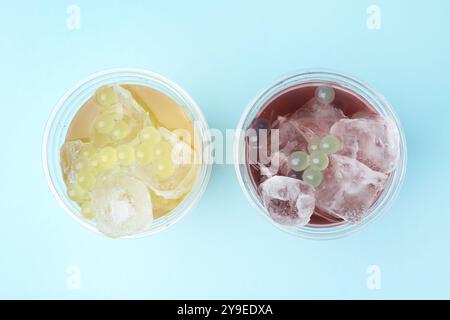 Leckerer Bubble Tee in Plastikbechern auf hellblauem Hintergrund, flach gelegt Stockfoto