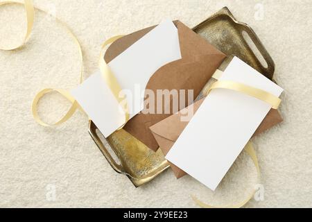 Leere Karten, Umschläge und Farbband auf beigefarbenem Tisch, flach gelegt Stockfoto