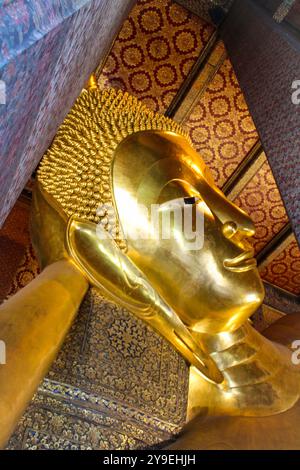 Wat Pho, auch Wat Po, ist ein buddhistischer Tempelkomplex im Bezirk Phra Nakhon in Bangkok, Thailand. Auch bekannt als Tempel des liegenden Buddha, ist sein offizieller Name Wat Phra Chetuphon Wimon Mangkhalaram Rajwaramahawihan. Der liegende Buddha, die Figur ist 15 m hoch und 46 m lang, und es ist eine der größten Buddha-Statuen in Thailand. Die Figur hat einen Ziegelkern, der mit Gips modelliert und geformt und dann vergoldet wurde. Stockfoto
