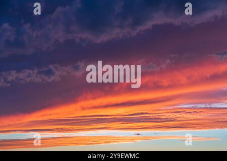 Leuchtender echter Himmel bei Sonnenuntergang Textur Hintergrund Overlay. Dramatische rote, orange und violette Wolken. Hochauflösende Fotografie, perfekt für den Ersatz des Himmels Stockfoto