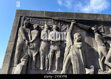 KZ Buchenwald DEU, Deutschland, Weimar, Thüringen, Thüringen, Thüringen, 29.07.2024 Stele mit Zynischer Schrift JEDEM das SEINE und Szene aus dem Lagerleben Symbol Befreiung und Haftung der Faschisten geschaffen von den Bildhauern Hans Kies , Rene Graetz und Waldemar Grimek an der Gedenkstaette vom ehemaligen Konzentrationslager KZ Buchenwald bei Weimar im Freistaat Thüringen Deutschland . Die heutige nationale Mahn- und Gedenkstaette auf dem einst eines der groessten Konzentrationslager auf deutschem Boden war zwischen 1937 und 1945 auf dem Ettersberg als Haftstaette zu Stockfoto