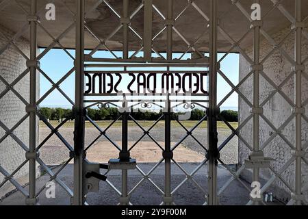 KZ Buchenwald DEU, Deutschland, Weimar, Thüringen, Thüringen, Thüringen, 29.07.2024 Zynische Schrift JEDEM das SEINE eingearbeitet in der Pforte vom Torgebaeude am Hauptwachtturm und Haupteingang auf der Gedenkstaette vom ehemaligen Konzentrationslager KZ Buchenwald bei Weimar im Freistaat Thüringen Deutschland. Die heutige nationale Mahn- und Gedenkstaette auf dem einst eines der groessten Konzentrationslager auf deutschem Boden war zwischen 1937 und 1945 auf dem Ettersberg als Haftstaette zur Zwangsarbeit betrieben. Insgesamt waren in diesem Zeitraum etwa 277,800 Mens Stockfoto