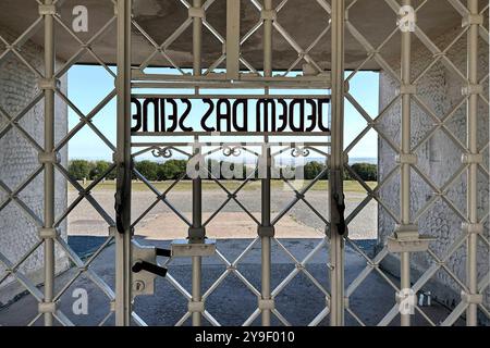 KZ Buchenwald DEU, Deutschland, Weimar, Thüringen, Thüringen, Thüringen, 29.07.2024 Zynische Schrift JEDEM das SEINE eingearbeitet in der Pforte vom Torgebaeude am Hauptwachtturm und Haupteingang auf der Gedenkstaette vom ehemaligen Konzentrationslager KZ Buchenwald bei Weimar im Freistaat Thüringen Deutschland. Die heutige nationale Mahn- und Gedenkstaette auf dem einst eines der groessten Konzentrationslager auf deutschem Boden war zwischen 1937 und 1945 auf dem Ettersberg als Haftstaette zur Zwangsarbeit betrieben. Insgesamt waren in diesem Zeitraum etwa 277,800 Mens Stockfoto