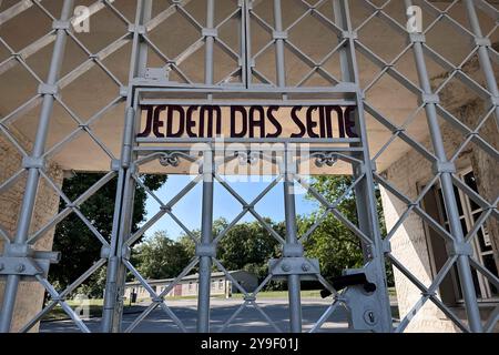 KZ Buchenwald DEU, Deutschland, Weimar, Thüringen, Thüringen, Thüringen, 29.07.2024 Zynische Schrift JEDEM das SEINE eingearbeitet in der Pforte vom Torgebaeude am Hauptwachtturm und Haupteingang auf der Gedenkstaette vom ehemaligen Konzentrationslager KZ Buchenwald bei Weimar im Freistaat Thüringen Deutschland. Die heutige nationale Mahn- und Gedenkstaette auf dem einst eines der groessten Konzentrationslager auf deutschem Boden war zwischen 1937 und 1945 auf dem Ettersberg als Haftstaette zur Zwangsarbeit betrieben. Insgesamt waren in diesem Zeitraum etwa 277,800 Mens Stockfoto