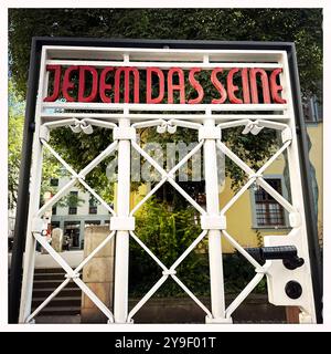 KZ Buchenwald DEU, Deutschland, Weimar, Thüringen, Thüringen, Thüringen, 29.07.2024 Originalgetreue Kopie von 2009 mit Zynischer Schrift JEDEM das SEINE gestaltet von Franz ehrlich 1938 eingearbeitet in der Pforte vom Torgebaeude am Hauptwachtturm und Haupteingang auf der Gedenkstaette vom ehemaligen Konzentrationslager KZ Buchenwald bei Weimar im Freistaat Thüringen Deutschland. Die heutige nationale Mahn- und Gedenkstaette auf dem einst eines der groessten Konzentrationslager auf deutschem Boden war zwischen 1937 und 1945 auf dem Ettersberg als Haftstaette zur Zwangsa Stockfoto