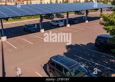 Duluth, MN, USA-15. September 2024: Elektroautos laden auf einem Parkplatz unter Solarpaneelen auf. Stockfoto