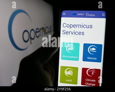 Person, die ein Handy hält, mit Webseite des ESA-Erdbeobachtungsprojekts Copernicus auf dem Bildschirm vor dem Logo. Konzentrieren Sie sich auf die Mitte des Telefondisplays. Stockfoto