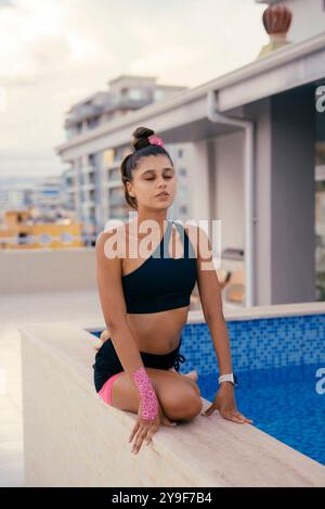 Genießen Sie ein entspannendes Yoga am Pool und üben Sie Einen ruhigen und friedlichen Moment für Geist und Körper Stockfoto