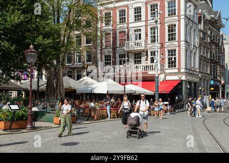 Man spaziert entlang der Terrassen auf dem Leidseplein in der Nähe der Leidsestraat in der Altstadt von Amsterdam. Stockfoto