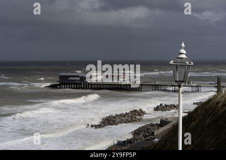 Cromer Pier and Theatre, North Norfolk, Norfolk, England, Großbritannien - Blick auf den Pier mit rauem, dramatischem Meer. Stockfoto
