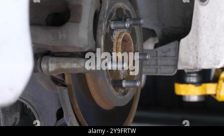 Nahaufnahme der Radnabe und Bremsscheibenbaugruppe des Fahrzeugs bei der Autoreparatur Stockfoto