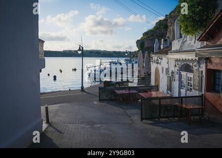 Blick auf den Hafen von Cales Fonts am Morgen mit kleinen Booten und Restaurants in der Stadt Mahon und es Castell auf der Insel Menorca auf den balearen Stockfoto