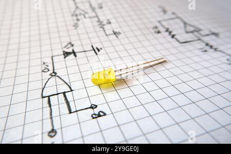 Gelbe LED auf einem Logikschaltplan. Konzept für digitale elektronische oder technologische Projekte. Konzentriert sich auf die LED. Stockfoto