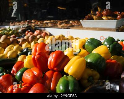 Gemüse und Obst im Ladengeschäft. Paprika in allen Farben. Äpfel und Zitronen im Hintergrund. Stockfoto