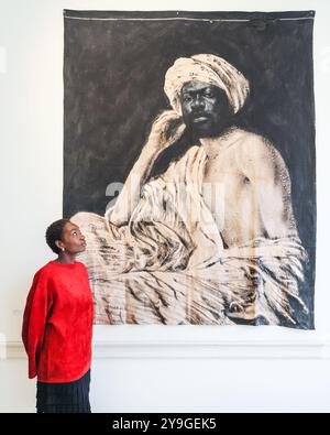 London, Großbritannien. Oktober 2024. Ein Vertreter der Galerie Eric Dupont mit Romeo Mivekannin, Portrait d'un jeune Egypt, d'Apres Lehnert et Landrock, 2021. 1-54 die Contemporary African Art Fair feiert ihre 12. Auflage im Somerset House mit der Sonderinstallation. Über 60 Galerien und 160 Künstler aus Afrika und der Diaspora sind dieses Jahr auf der Messe zu sehen. Quelle: Imageplotter/Alamy Live News Stockfoto
