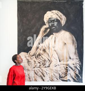 London, Großbritannien. Oktober 2024. Ein Vertreter der Galerie Eric Dupont mit Romeo Mivekannin, Portrait d'un jeune Egypt, d'Apres Lehnert et Landrock, 2021. 1-54 die Contemporary African Art Fair feiert ihre 12. Auflage im Somerset House mit der Sonderinstallation. Über 60 Galerien und 160 Künstler aus Afrika und der Diaspora sind dieses Jahr auf der Messe zu sehen. Quelle: Imageplotter/Alamy Live News Stockfoto