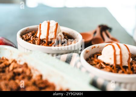 Apfelstreuselkuchen in Keramikgeschirr mit Eiscreme Stockfoto