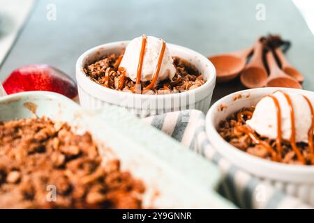 Apfelstreuselkuchen in Keramikgeschirr mit Eiscreme Stockfoto