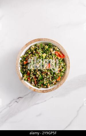 Tabbouleh-Salat mit Tomaten auf Marmor-Hintergrund Stockfoto