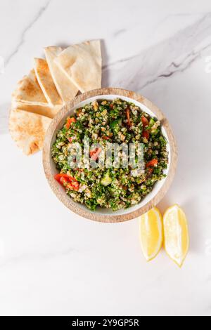 Tabbouleh-Salat mit Tomaten, Pita-Brot und Zitronenscheiben Stockfoto