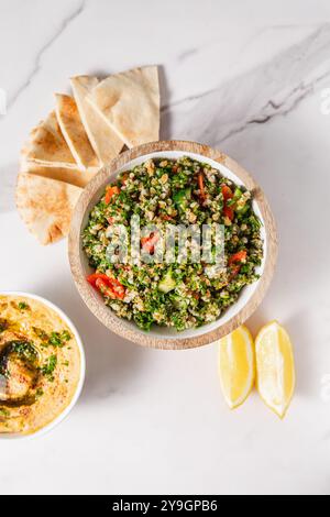 Tabbouleh-Salat mit Tomaten, Pita-Brot, Zitronenscheiben und Hummus Stockfoto