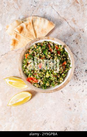 Tabbouleh-Salat mit Tomaten, Pita-Brot und Zitronenscheiben Stockfoto