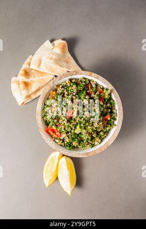 Tabbouleh-Salat mit Tomaten, Pita-Brot und Zitronenscheiben Stockfoto