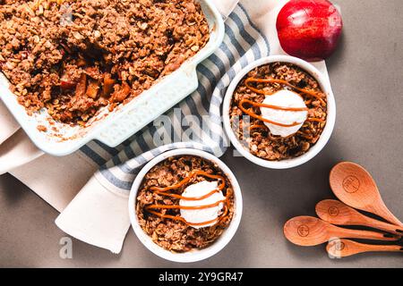 Apfelstreuselkuchen in Keramikgeschirr mit Eiscreme Stockfoto