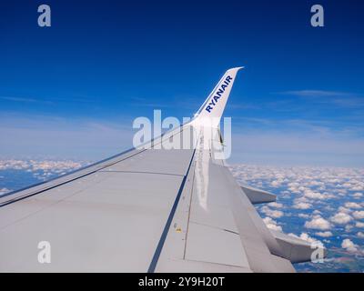 Flügel des Ryanair Passagierflugzeugs am blauen Himmel vom Fenster aus gesehen Stockfoto