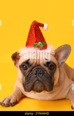 Niedlicher Mops mit Weihnachtsmann-Hut auf gelbem Hintergrund Stockfoto