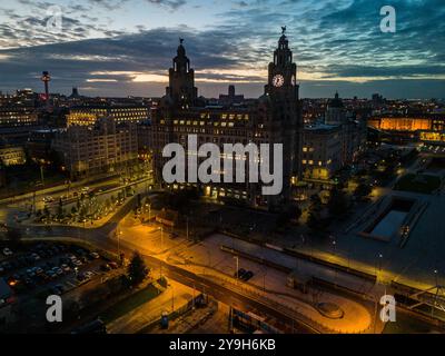 Diese fesselnde Luftaufnahme zeigt das beleuchtete königliche Lebergebäude und das faszinierende Stadtbild von liverpool bei Nacht Stockfoto