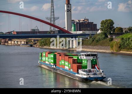Das mit Containern beladene niederländische Frachtschiff Vrido auf dem Rhein bei Duisburg flussabwärts hinter der sogenannten Solidaritätsbrücke über den Rhein, Stockfoto