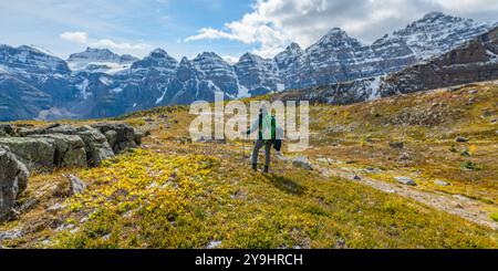 Unglaubliche Herbstausblicke auf das Larch Valley und den malerischen Sentinal Pass im September mit leuchtend gelben Bäumen und einer Frau, die eine Person wandert Stockfoto