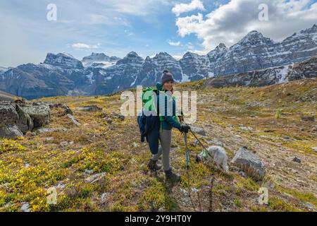 Unglaubliche Herbstausblicke auf das Larch Valley und den malerischen Sentinal Pass im September mit leuchtend gelben Bäumen und einer Frau, die eine Person wandert Stockfoto