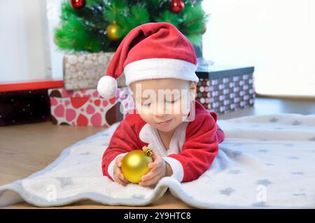 Lustiger Junge, der mit Weihnachtsmütze getragen wurde Stockfoto