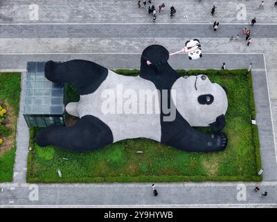 CHENGDU, CHINA - 9. OKTOBER 2024 - Eine 26 Meter lange Skulptur des schwersten Riesenpandas der Welt, mit einem Gewicht von 130 Tonnen, liegt auf dem Boden und hält eine se Stockfoto
