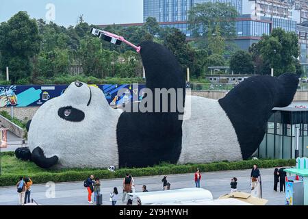 CHENGDU, CHINA - 9. OKTOBER 2024 - Eine 26 Meter lange Skulptur des schwersten Riesenpandas der Welt, mit einem Gewicht von 130 Tonnen, liegt auf dem Boden und hält eine se Stockfoto