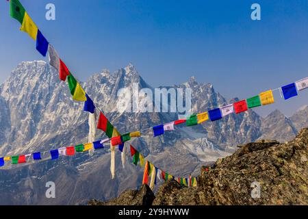 Traditionelle tibetische Gebetsfahnen im Himalaya-Gebirge in Nepal. Wunderschöne Landschaft mit Bergen und blauem Himmel. Rote, gelbe, grüne, blaue und weiße Flagge Stockfoto