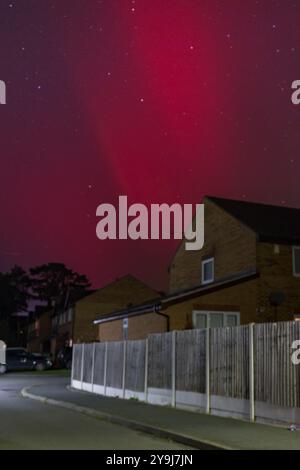 LEOMINSTER, Großbritannien - 10. OKTOBER 2024; die Nordlichter leuchten hinter einer Wohnstraße in Leominster, Herefordshire, Großbritannien. Stockfoto