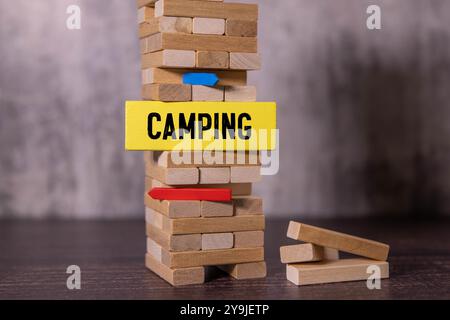 Wort-Camping geschrieben in kleinen hölzernen Alphabetwürfeln auf isoliertem weißen Hintergrund, Reisekonzept Stockfoto