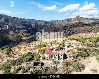 Berge und Olivenhaine rund um Geisterstadt von einer Drohne, Pentedattilo Village, Kalabrien, Italien, Europa Stockfoto