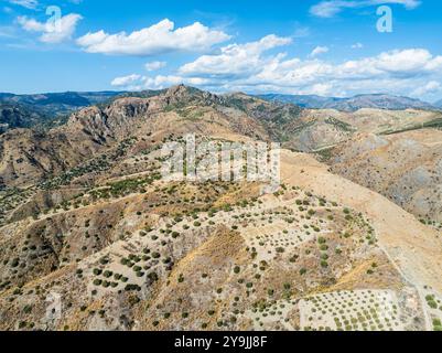 Berge und Olivenhaine rund um Geisterstadt von einer Drohne, Pentedattilo Village, Kalabrien, Italien, Europa Stockfoto