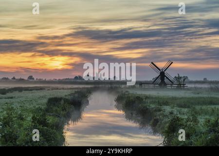 Kleine niederländische Windmühle und Sonnenaufgang im Dorf Zaanse Schans, Amsterdam Niederlande Stockfoto