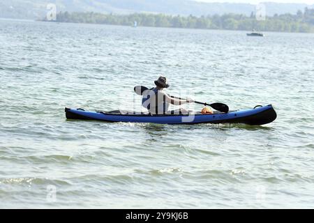 Themenbild Wetter Ein Mann mit einem Paddelboot auf dem Bodensee die Sommersaison eröffnete am Bodensee an den Feiertagen des 1. Mai (Tag der Arbeit) Stockfoto