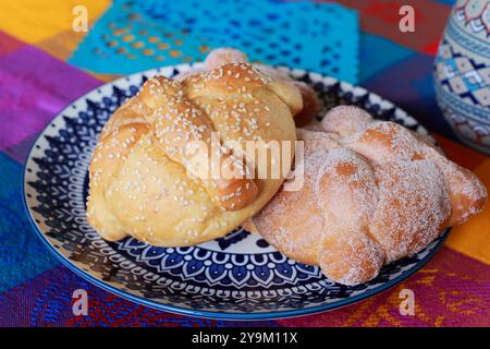 Traditioneller Pan de Muerto auf einer farbenfrohen Tischdecke Stockfoto