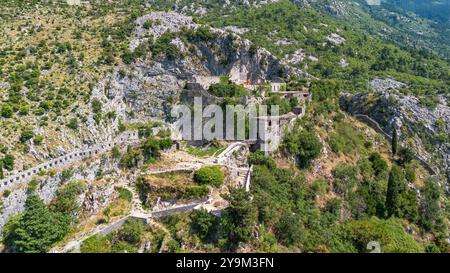 Aus der Vogelperspektive auf die Festung San Giovanni (St. Johannes), die auf einem Felsvorsprung über der Altstadt von Kotor in Montenegro erbaut wurde - mittelalterliche Ruinen überblickend Stockfoto