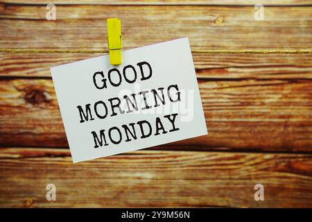 Guten Morgen Montag Text auf Papierkarte, die an der Wand hängt, mit Kleiderschachteln Stockfoto