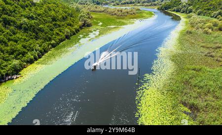 Aus der Vogelperspektive eines Bootes, das auf der gewundenen Rijeka Crnojevića (Fluss Crnojević) in den Bergen in der Nähe des Skadar-Sees in Montenegro navigiert Stockfoto