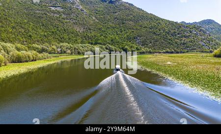 Aus der Vogelperspektive eines Bootes, das auf der gewundenen Rijeka Crnojevića (Fluss Crnojević) in den Bergen in der Nähe des Skadar-Sees in Montenegro navigiert Stockfoto