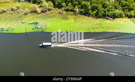 Aus der Vogelperspektive eines Bootes, das auf der gewundenen Rijeka Crnojevića (Fluss Crnojević) in den Bergen in der Nähe des Skadar-Sees in Montenegro navigiert Stockfoto